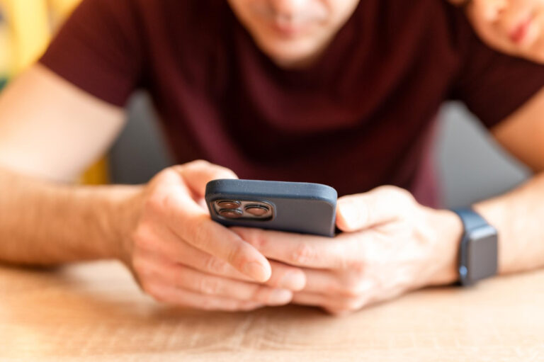 02232022-moscow-man-using-modern-technology-mobile-phone-smartphone-iphone-touching-digital-screen-people-texting-message-social-media-male-hand-with-wrist-smart-apple-watch