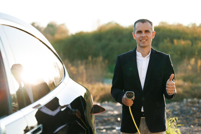 portrait-caucasian-businessman-standing-near-electric-charging-station-looking-camera