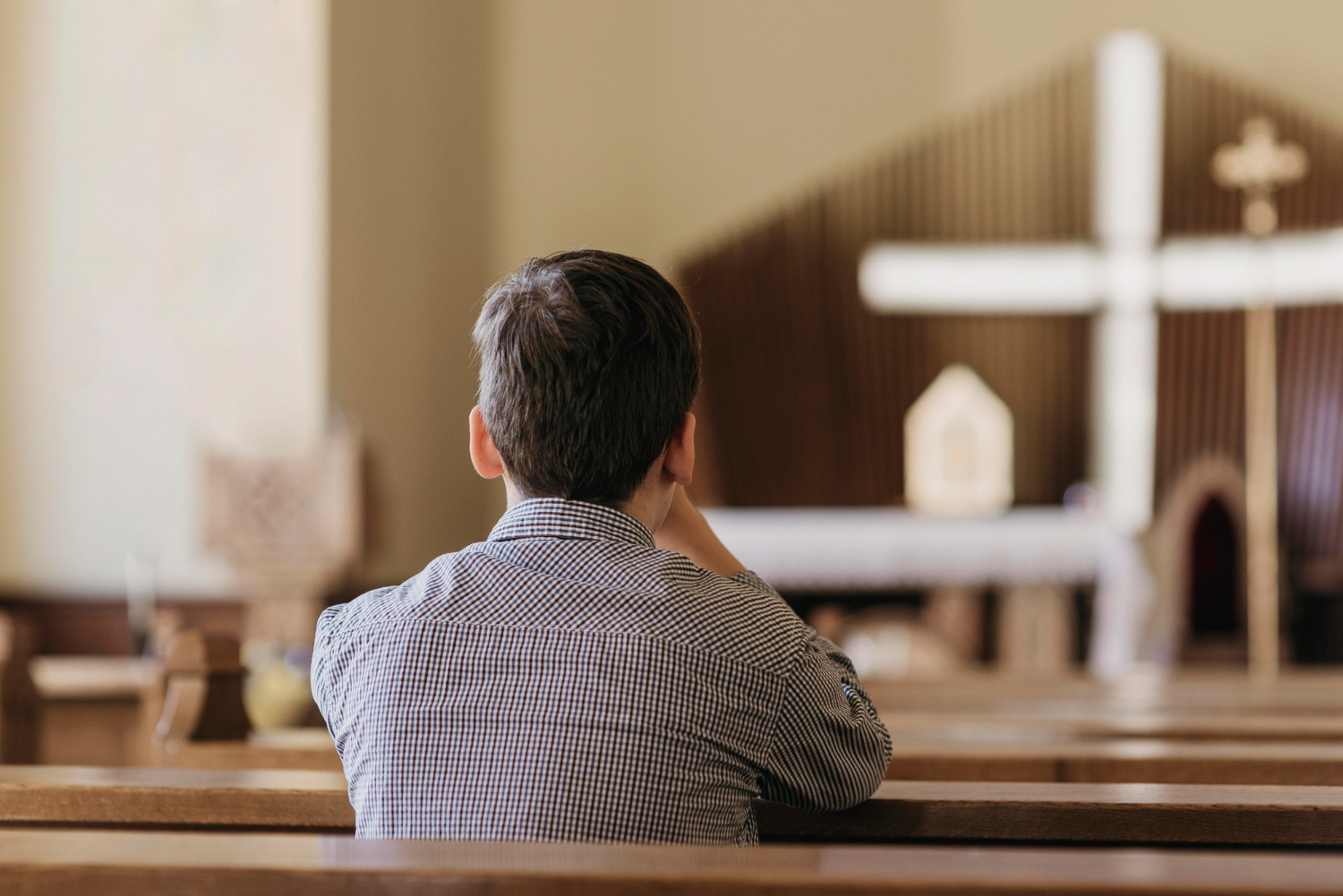 back-view-young-boy-praying-church